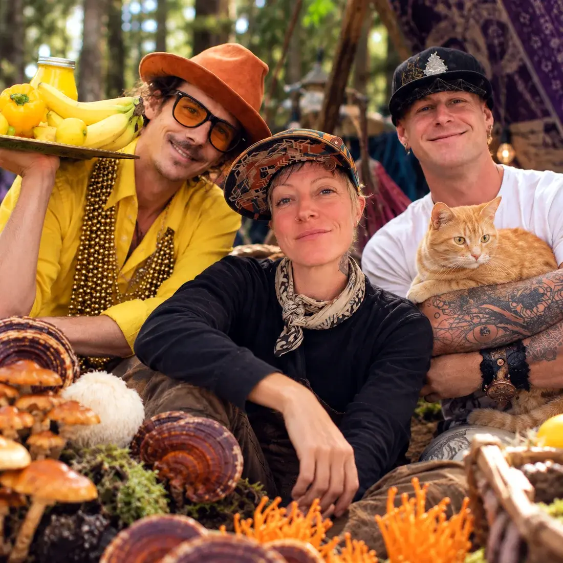 REWILD founders Pete, Jade and Sean in the forest with mushrooms and an orange cat