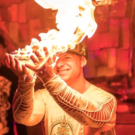 Sean Turner, co-founder of REWILD Mushrooms, smiling beside fire
